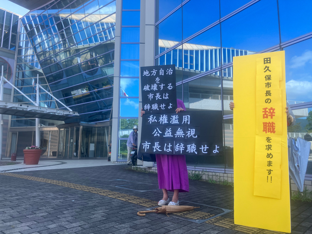辞職を求めるプラカードを持った市民