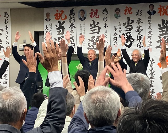 ばんざいをする杉本氏と陣営