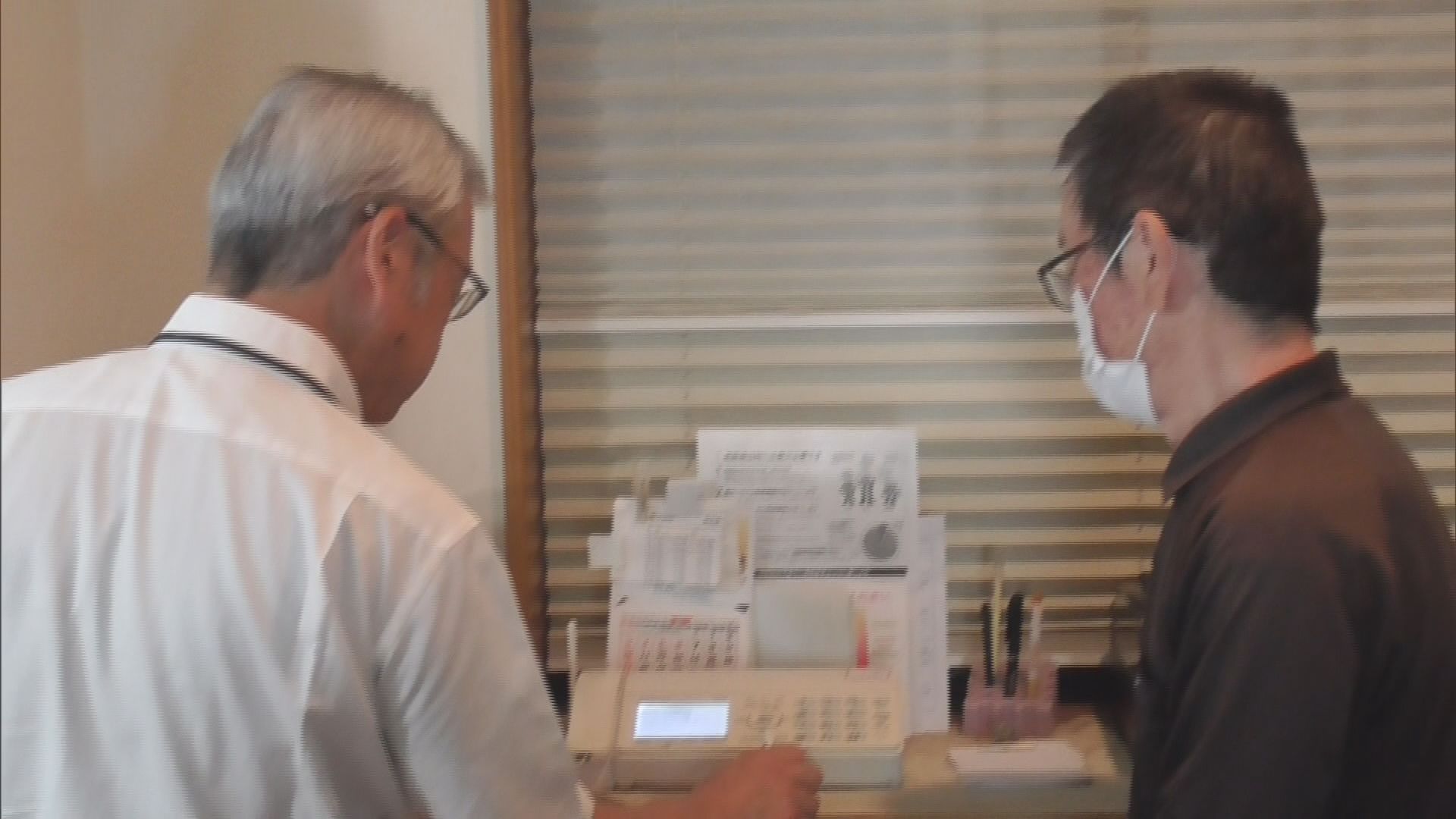 高齢者宅を訪問し固定電話の作業をする警察官