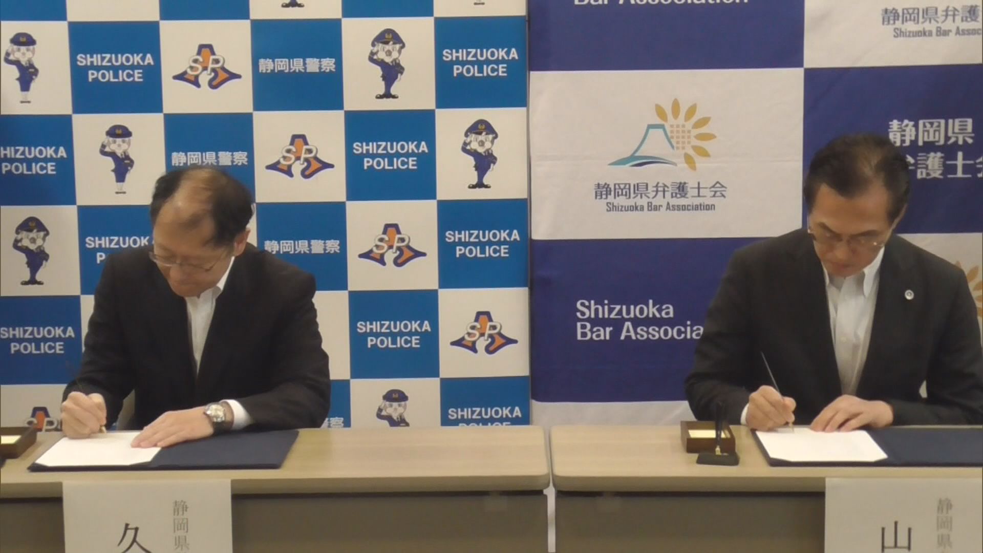 協定書に署名する久田誠県警本部長と山本正幸県弁護士会会長（右）